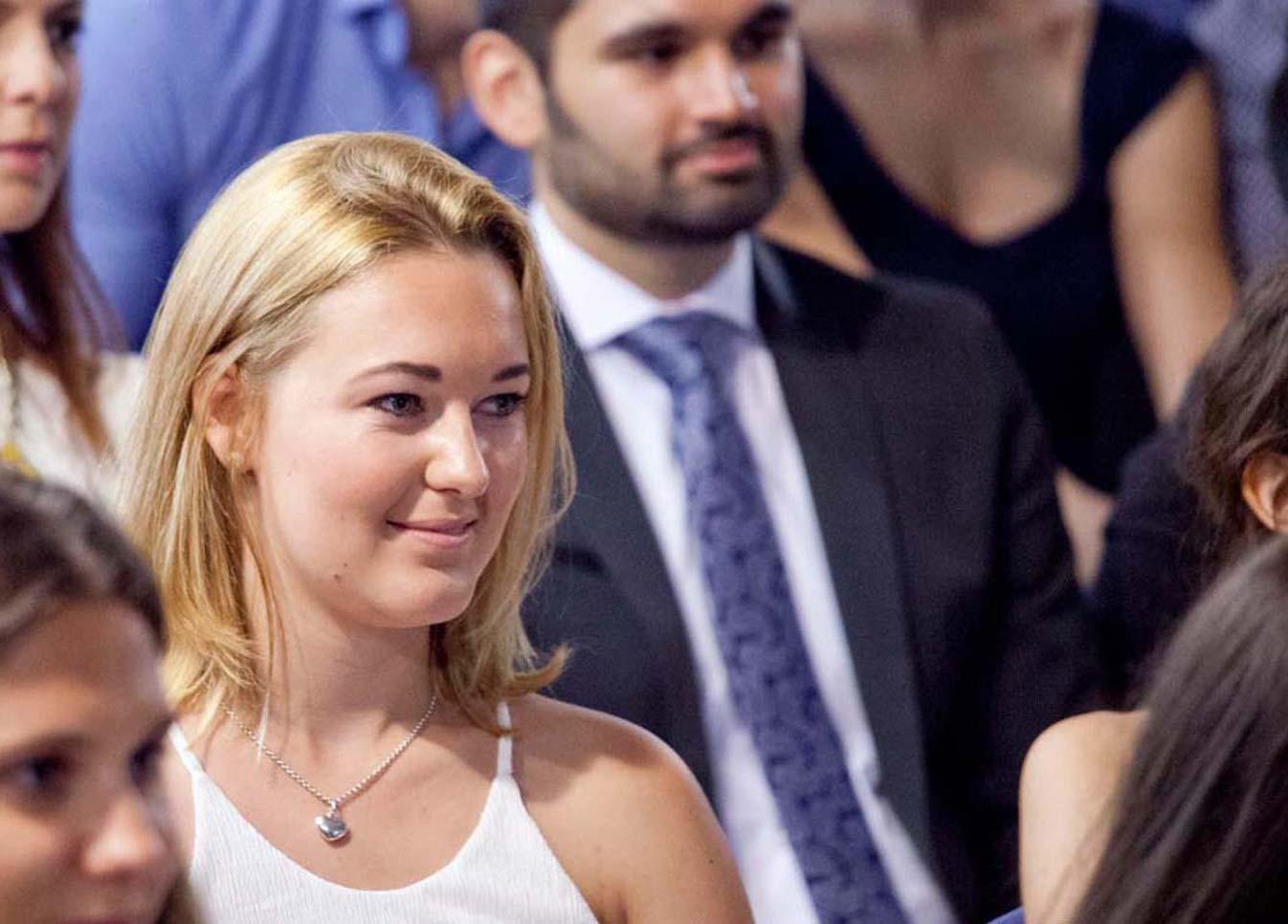 Young woman attending a formal event with people seated in the background