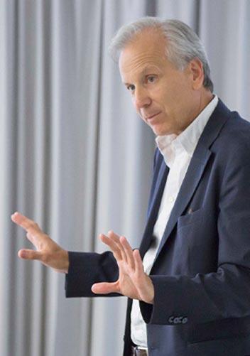 man wearing a shirt explains something to the audience